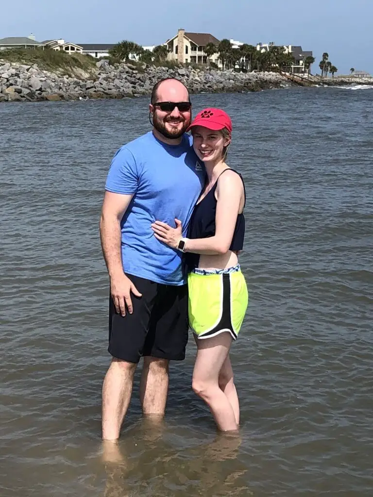 couple stand in the ocean during beach trip