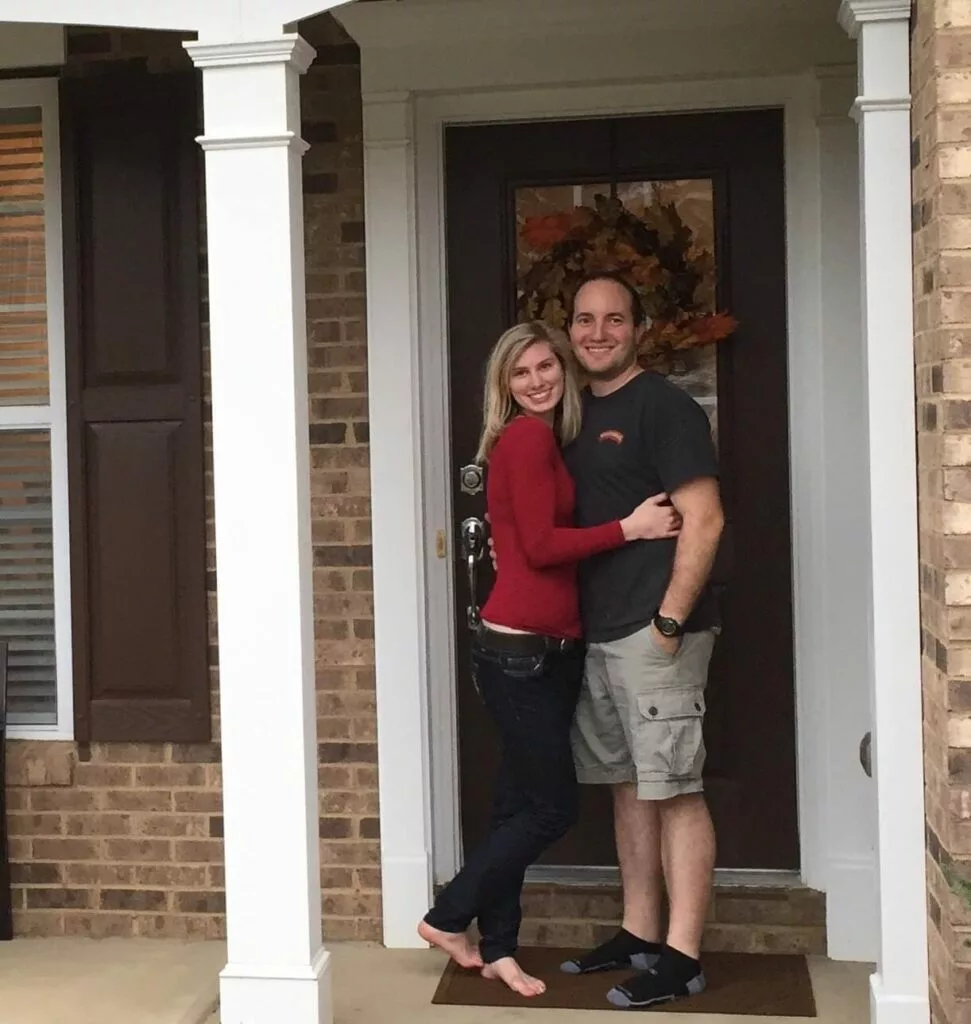 Husband and Wife stand in front of first home