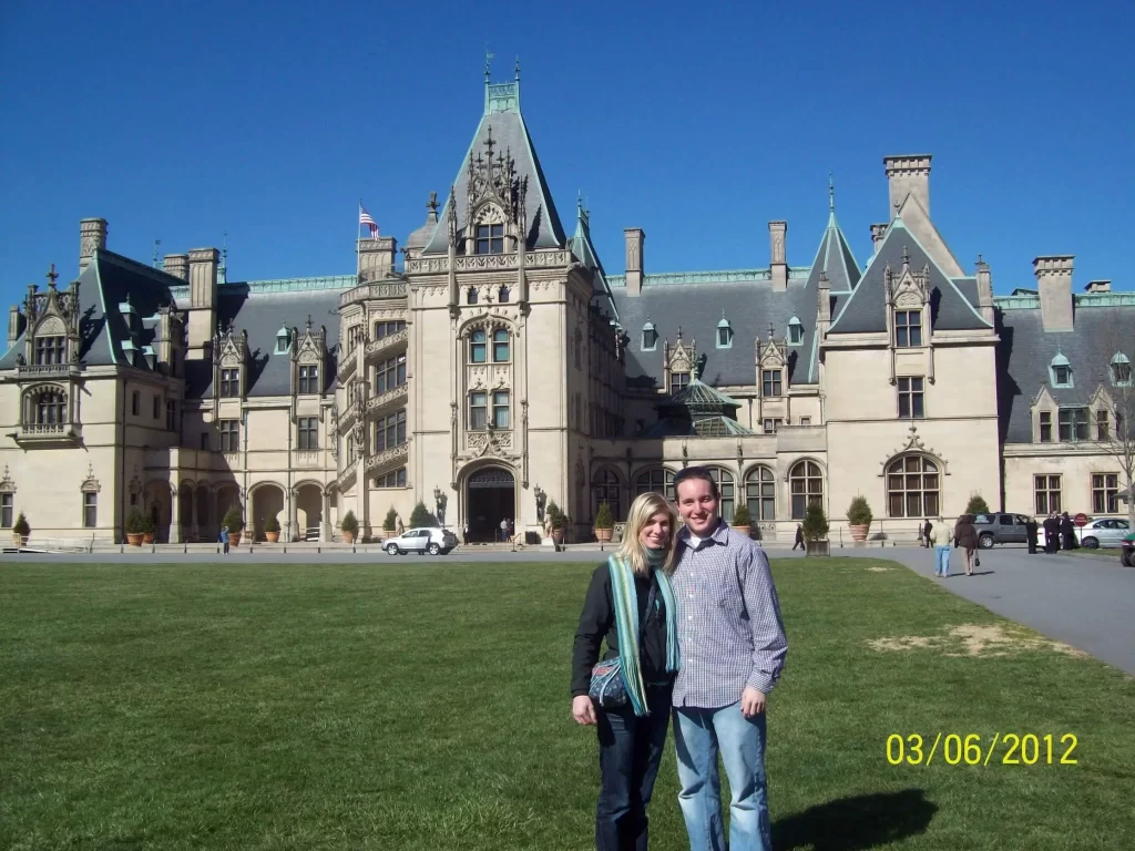 Husband and wife standing in front of the Biltmore Estate in Asheville, NC