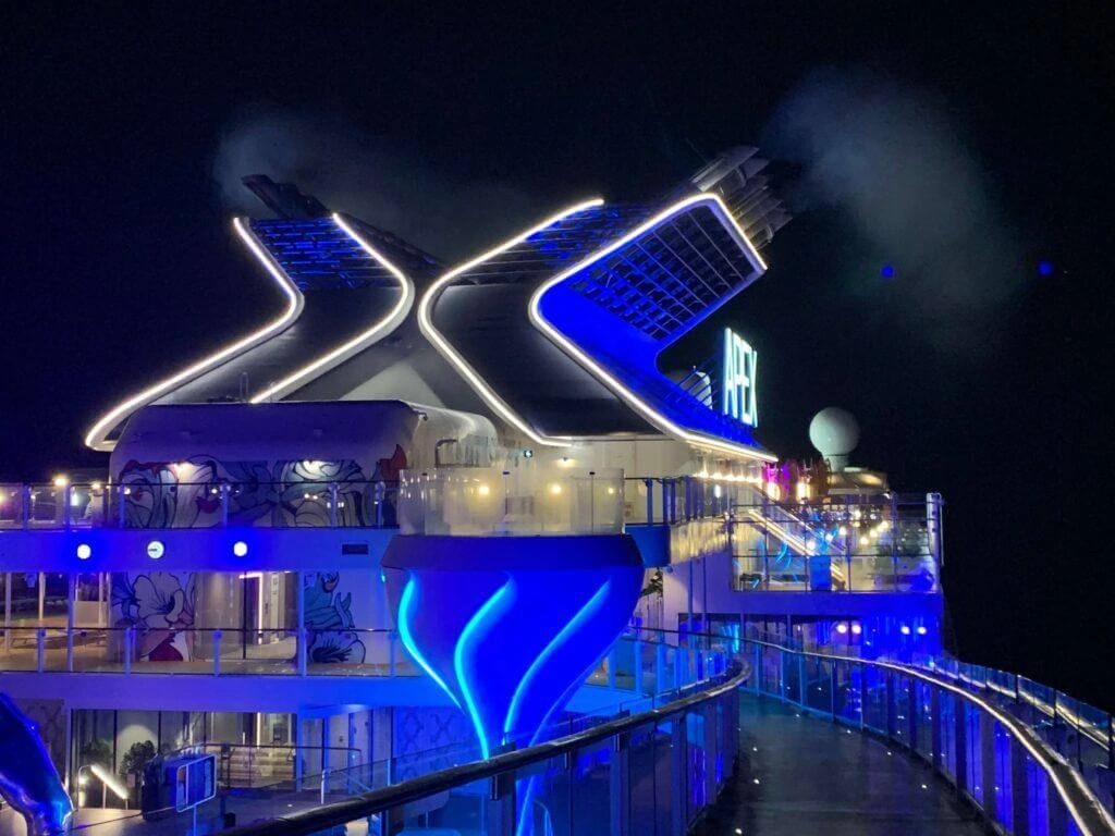 Celebrity Apex pool deck lit up blue at night