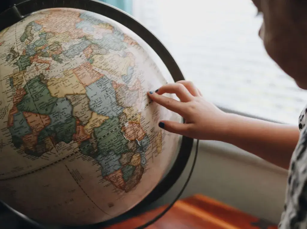 Child pointing at a place on a globe 