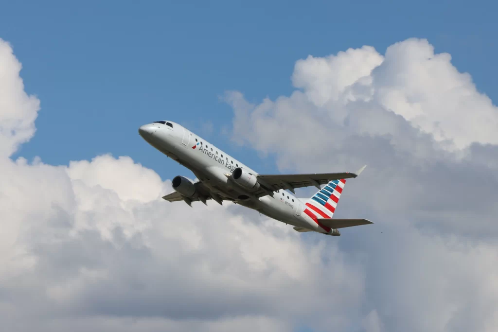 American Airlines plane flying with the clouds as a backdrop 