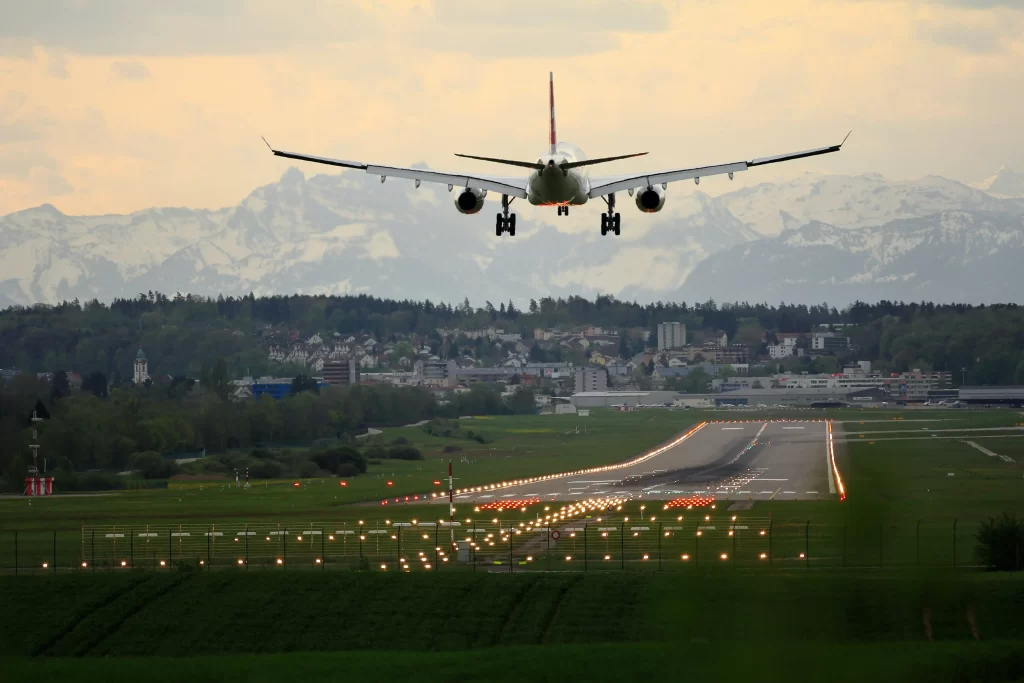 airplane landing at sunset with mountain backdrop